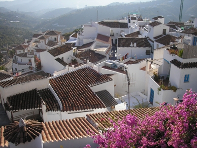 A misty and smokey view over the red clay tile rooftops of Frigiliana and down through the valley.